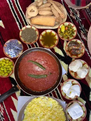 a table topped with lots of different types of food at غبار الطلح هاوس in Ma‘ān