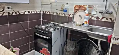 a small kitchen with a stove and a sink at غبار الطلح هاوس in Ma‘ān
