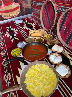 a table with a pan of food and other foods at غبار الطلح هاوس in Ma‘ān