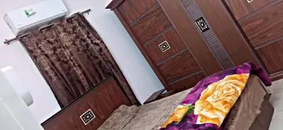 a bedroom with a bed and a wooden door at غبار الطلح هاوس in Ma‘ān