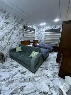 a living room with two couches and a stone wall at الكرك الثنية in Kerak