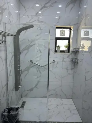 a white bathroom with a shower with a window at الكرك الثنية in Kerak