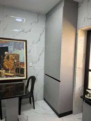 a painting on a wall next to a table and a chair at الكرك الثنية in Kerak
