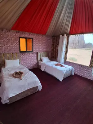 a bedroom with two beds with a dog laying on them at Wadi Rum Nomad Way Camp in Wadi Rum