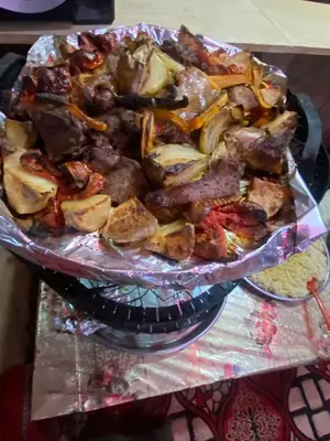 a plate of food with meat and vegetables on a table at Wadi Rum Nomad Way Camp in Wadi Rum