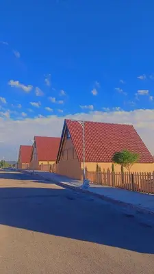 a row of buildings with red roofs and a fence at منتجع وأكواخ غصن in Al Jafr