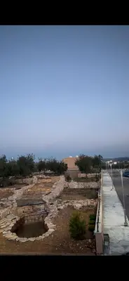 a stone wall next to a road near the ocean at The Branch Lodges in Ajloun