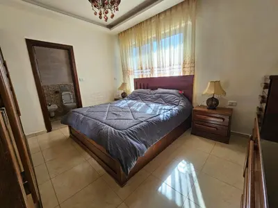 a bedroom with a bed and a dresser and a window at MK7 - Two Bedroom Apartment in Amman