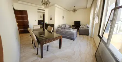 a living room with a table and a couch at MK7 - Two Bedroom Apartment in Amman