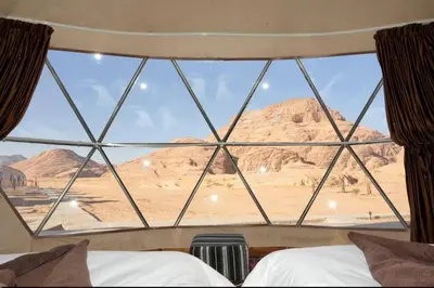 a view of the desert from a bedroom window at Wadi rum camp in Wadi Rum