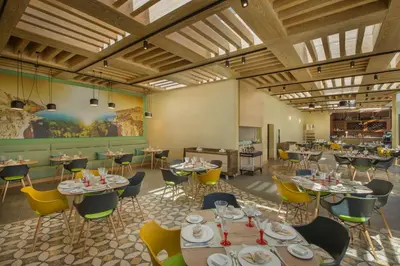 a dining room with tables and chairs and a bar at Hilton Dead Sea Resort & Spa in Sowayma