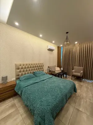 a bedroom with a large bed with a green blanket at Swefieh studio 8 in Amman