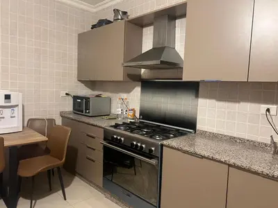 a kitchen with a stove top oven next to a table at Khalda apartment in Amman