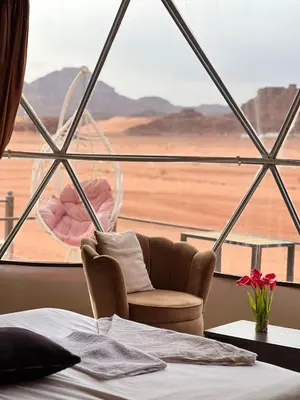 a room with a bed and a view of the desert at Golden Stars Luxury Camp Wadi Rum in Wadi Rum