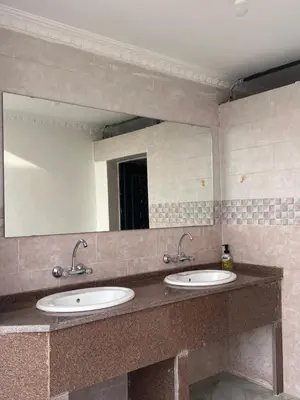 a bathroom with two sinks and a large mirror at Local experience in El Quweira