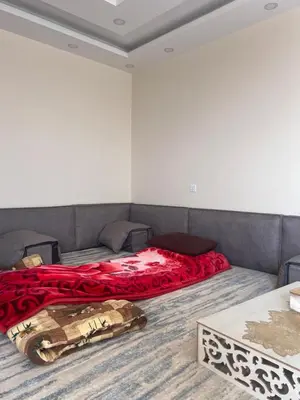 a bedroom with a bed with a red blanket at Local experience in El Quweira