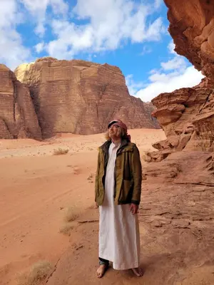 a man standing in the desert near some rocks at Wadi rum Breeze of calm in Wadi Rum