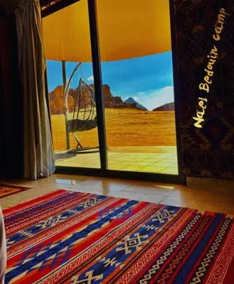 a room with a view of the desert through a glass door at Nile Bedouin Camp in Disah