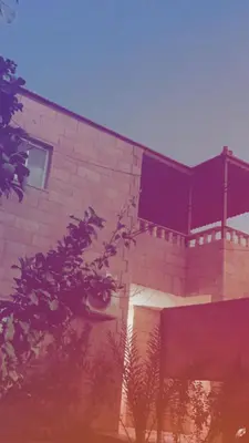 a red brick building with a window and a tree at Lozi House Cozy Stay in Al Azraq ash Shamālī