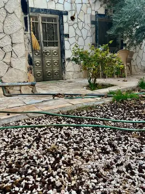 a pile of rocks in front of a building with a door at Lozi House Cozy Stay in Al Azraq ash Shamālī