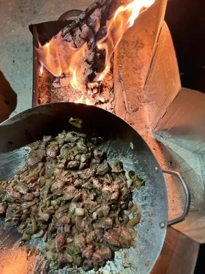 a pan of food is cooking in a stove at Lozi House Cozy Stay in Al Azraq ash Shamālī