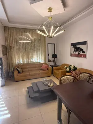 a living room with a couch and a table at Furnished luxurious apartment with a stunning view near Kling Hussein Business Park in Amman
