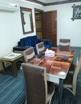 a room with a table and chairs and a couch at Royal Homes Jordan in Amman