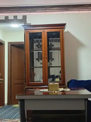 a wooden cabinet with glass doors in a room at Royal Homes Jordan in Amman