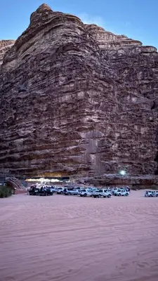 a group of cars parked in front of a mountain at Siella Pearl of Wadi Rum in Wadi Rum