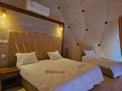 a bedroom with two beds in a tent at Luxury Wadi Rum Camp in Wadi Rum