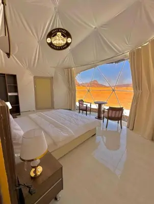 a bedroom with a large bed with a view of the desert at DESRT STARS lUXURY CAMP in Disah