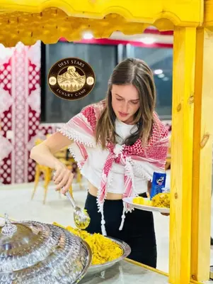 a woman is preparing food in a buffet at DESRT STARS lUXURY CAMP in Disah