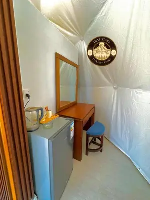 a room with a dresser and a desk in a tent at DESRT STARS lUXURY CAMP in Disah