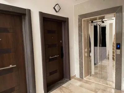 two wooden doors in a room with a mirror at شقة فندقية فاخرة في عمان قرب طريق المطار Luxury Living Near Airport Road in Amman