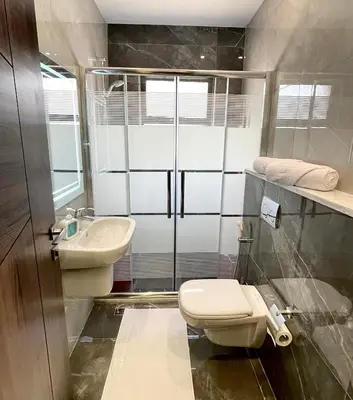 a bathroom with a toilet and a sink at شقة فندقية فاخرة في عمان قرب طريق المطار Luxury Living Near Airport Road in Amman