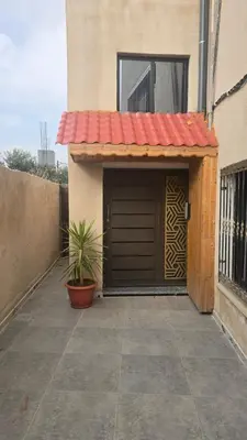 a garage with a door and a plant in front of it at اربد لواء الوسطية كفرعان مجسم البتراء