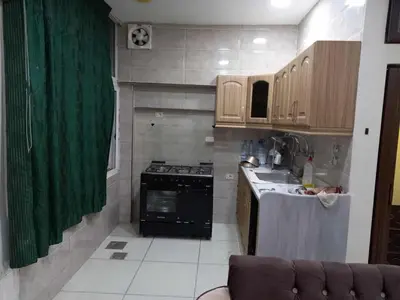 a small kitchen with a stove and a sink at Hana Home in Amman