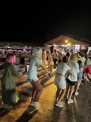 a group of women dancing on a beach at night at Hillawi Desert Camp Wadi Rum in Disah