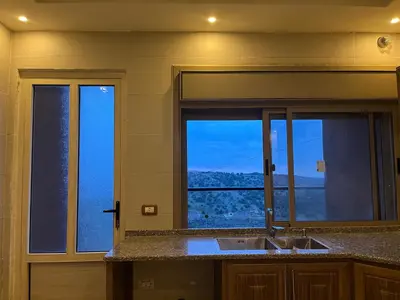 a kitchen with a sink and a window with a view at شقه للإيجار عجلون -رأس منيف in Ajloun