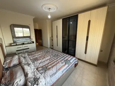 a bedroom with a large bed and a mirror at شقه للإيجار عجلون -رأس منيف in Ajloun