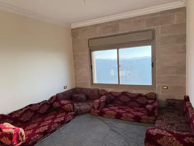 a living room with a couch and a window at شقه للإيجار عجلون -رأس منيف in Ajloun