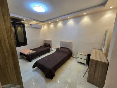 a room with two beds and a television in it at الياقوت للشقق الفندقية