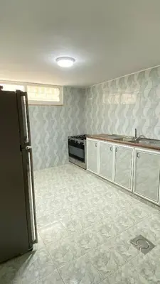 a kitchen with a sink and a refrigerator at W3 property in Kerak