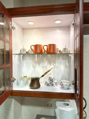 a shelf with dishes and pots and pans on it at Welcome to our prime location flat in Amman