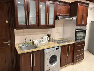 a kitchen with a sink and a washing machine at 7th Circle 1 bedroom flat Amman, pleasant views in Amman