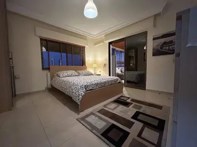 a bedroom with a bed and a large window at 7th Circle 1 bedroom flat Amman, pleasant views in Amman
