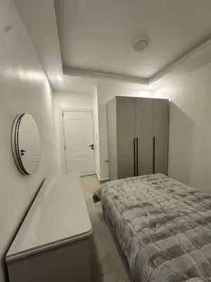 a bedroom with a bed and a mirror and a table at Furnished Apartment in Bushrá