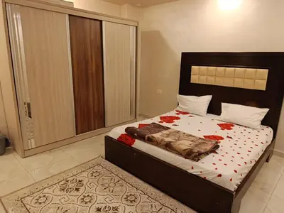 a bedroom with a bed with red flowers on it at غرفه مفروشه ومكيفه بجانب الكارفور اربد in Irbid