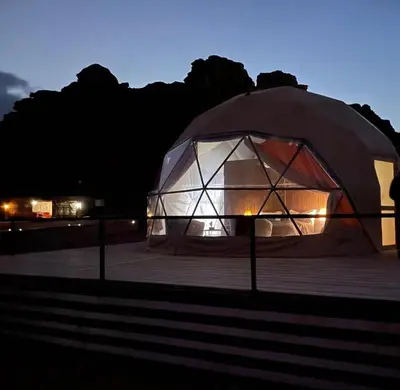 a large tent is lit up at night at Wadi rum magic Luxury in Wadi Rum