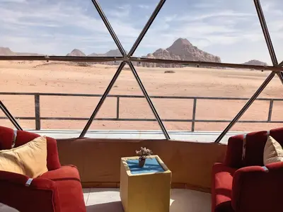 a room with two chairs and a view of the desert at Star Gate Camp in Wadi Rum
